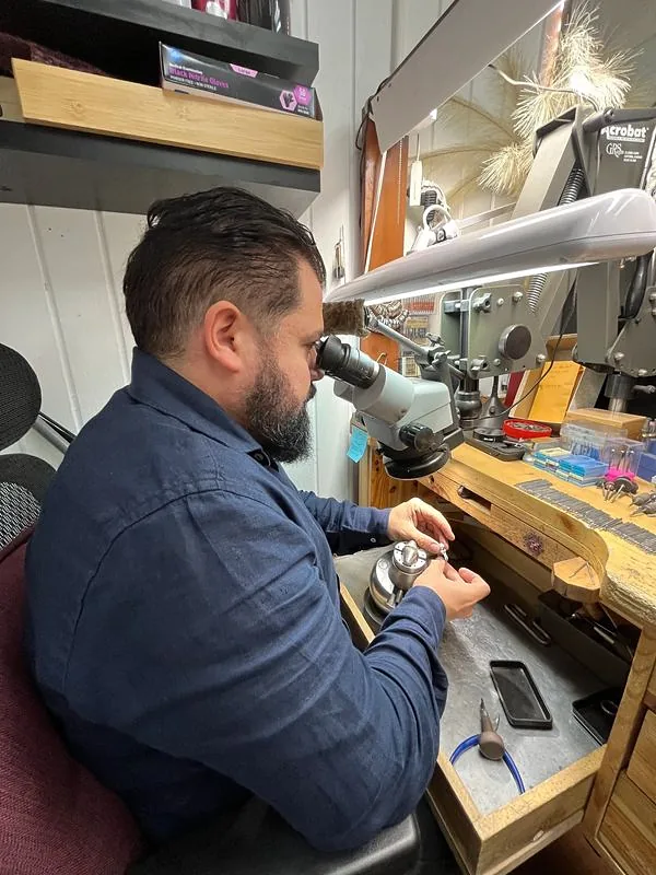 Adriano at his bench, working on a ring under the microscope in the Boston atelier
