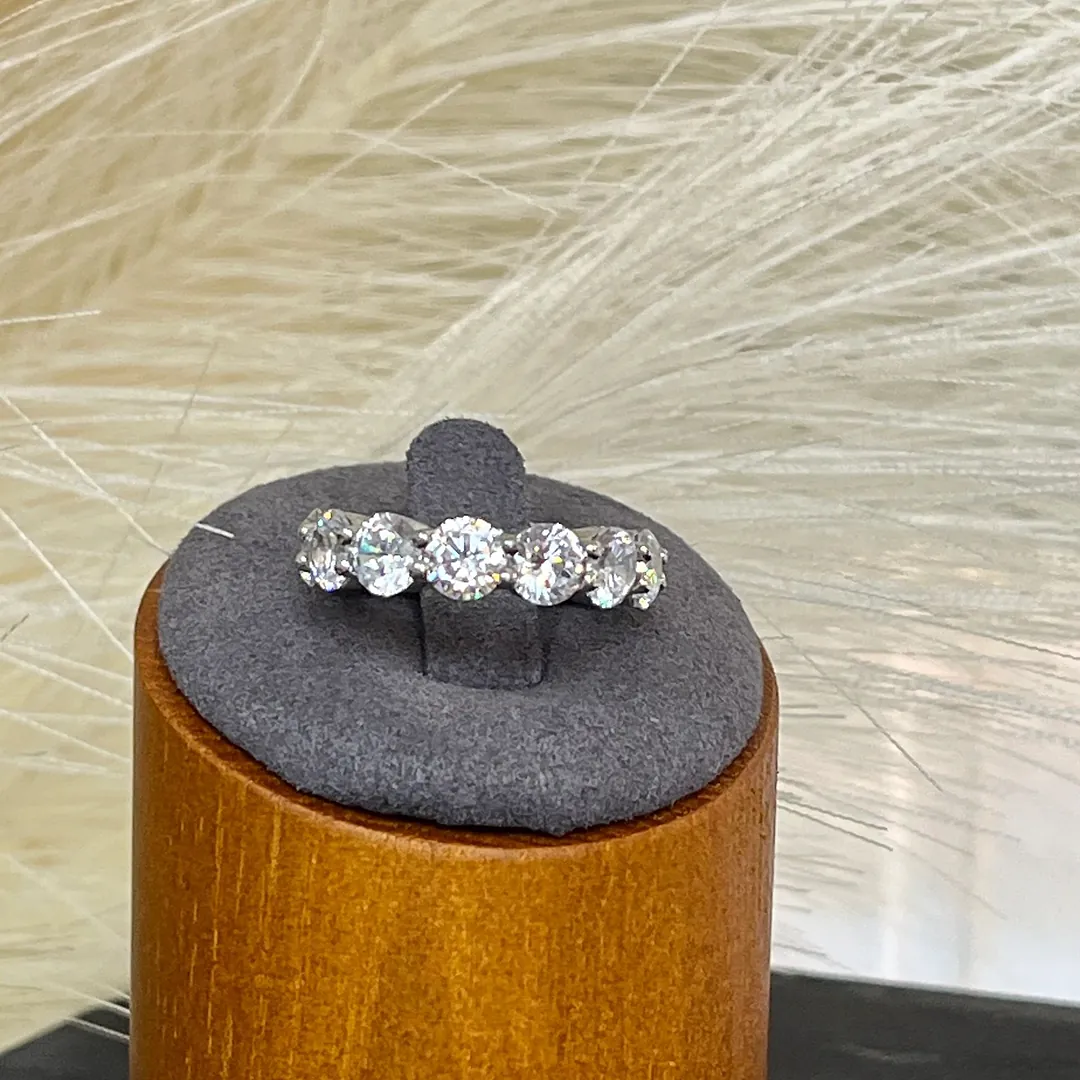 Five-stone diamond ring on a wooden display pedestal