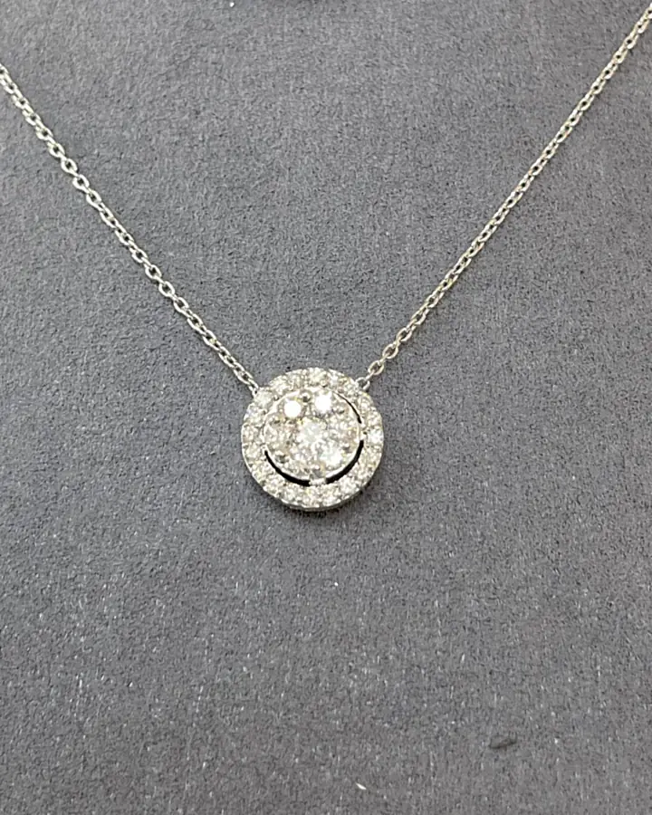 Halo diamond pendant necklace photographed on dark slate